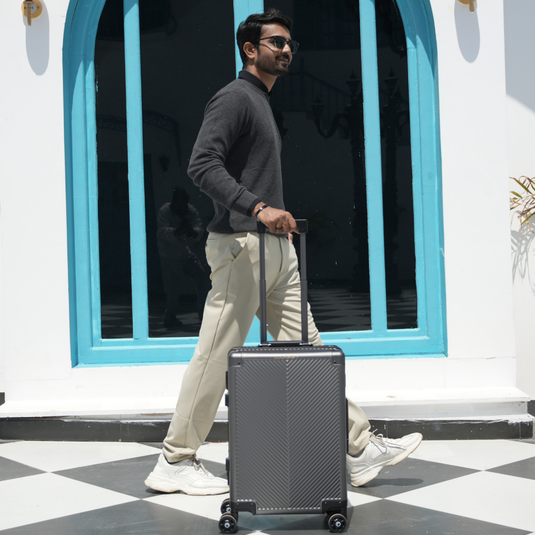 A man pulling a black aluminium trolley luggage bag behind him.