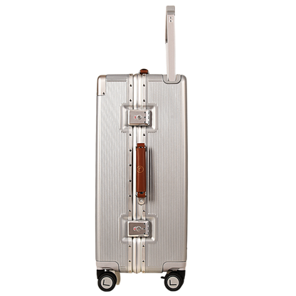 A silver aluminum hard-shell suitcase with a brown leather handle and silver metal lock hardware, shown from the back against a plain white background.