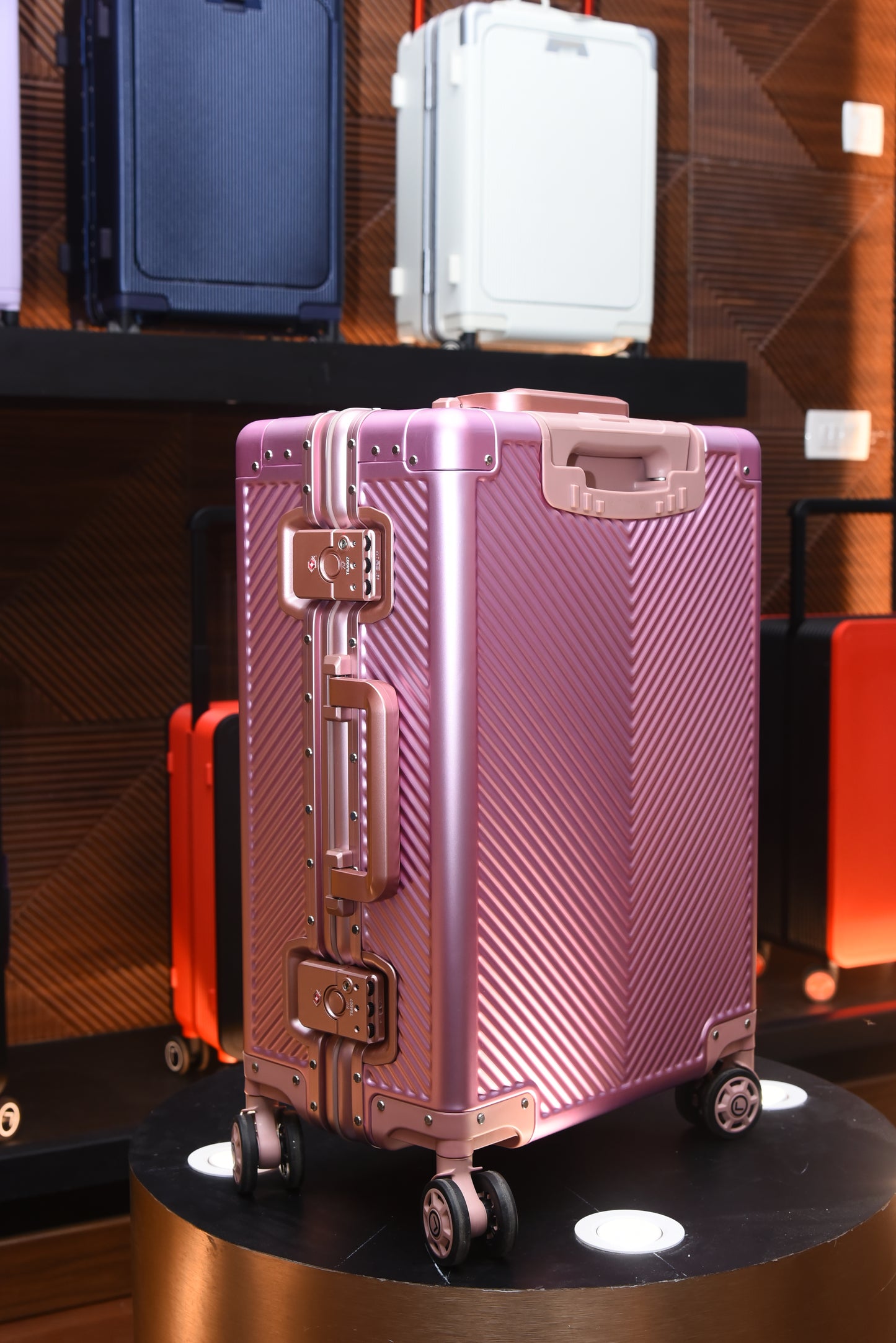 Pink suitcase with a textured surface on a reflective surface